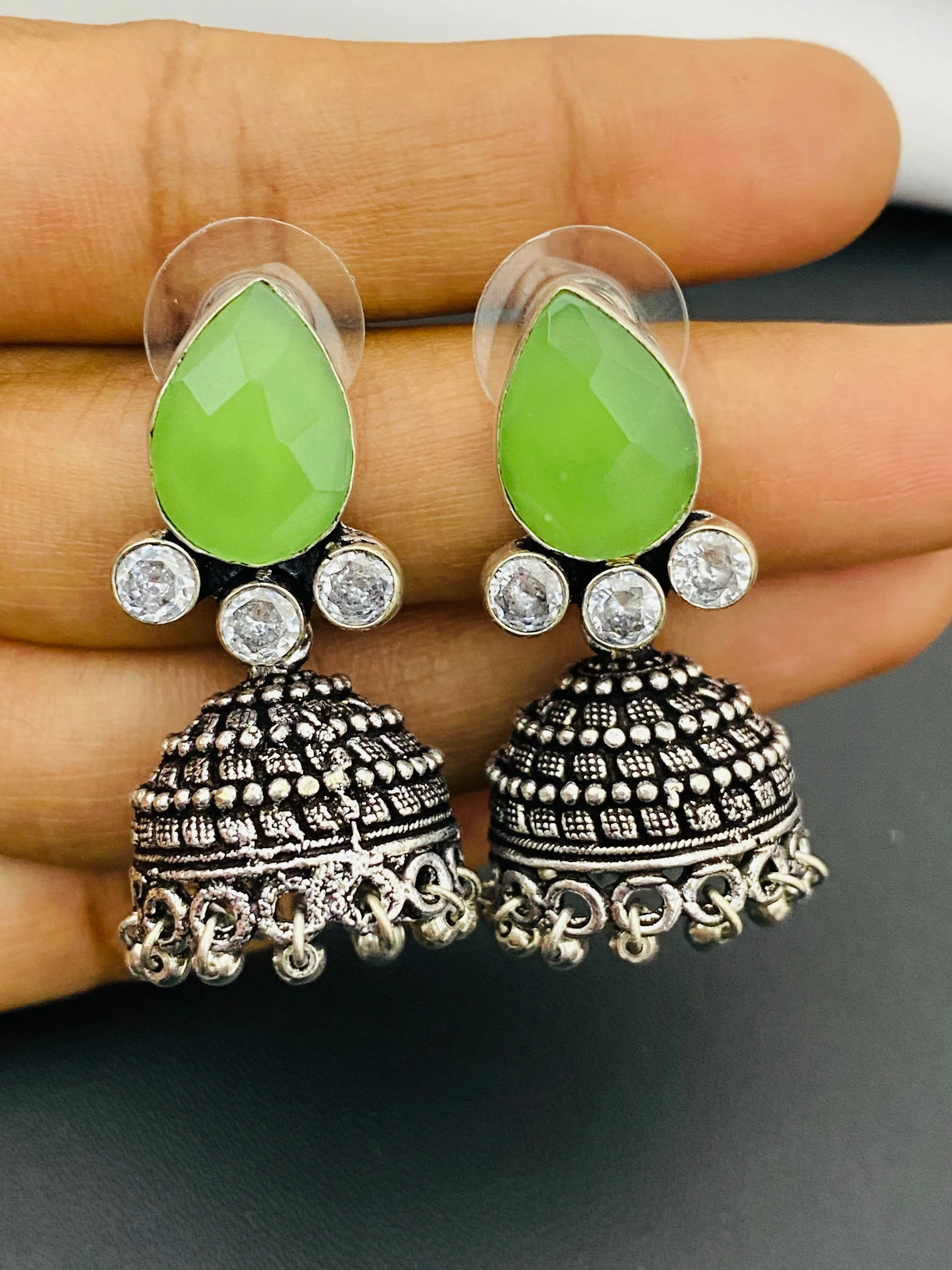 Lovely Green AD Stone Beaded Silver Toned Designer Jhumka Earrings With Black Pearl Drops