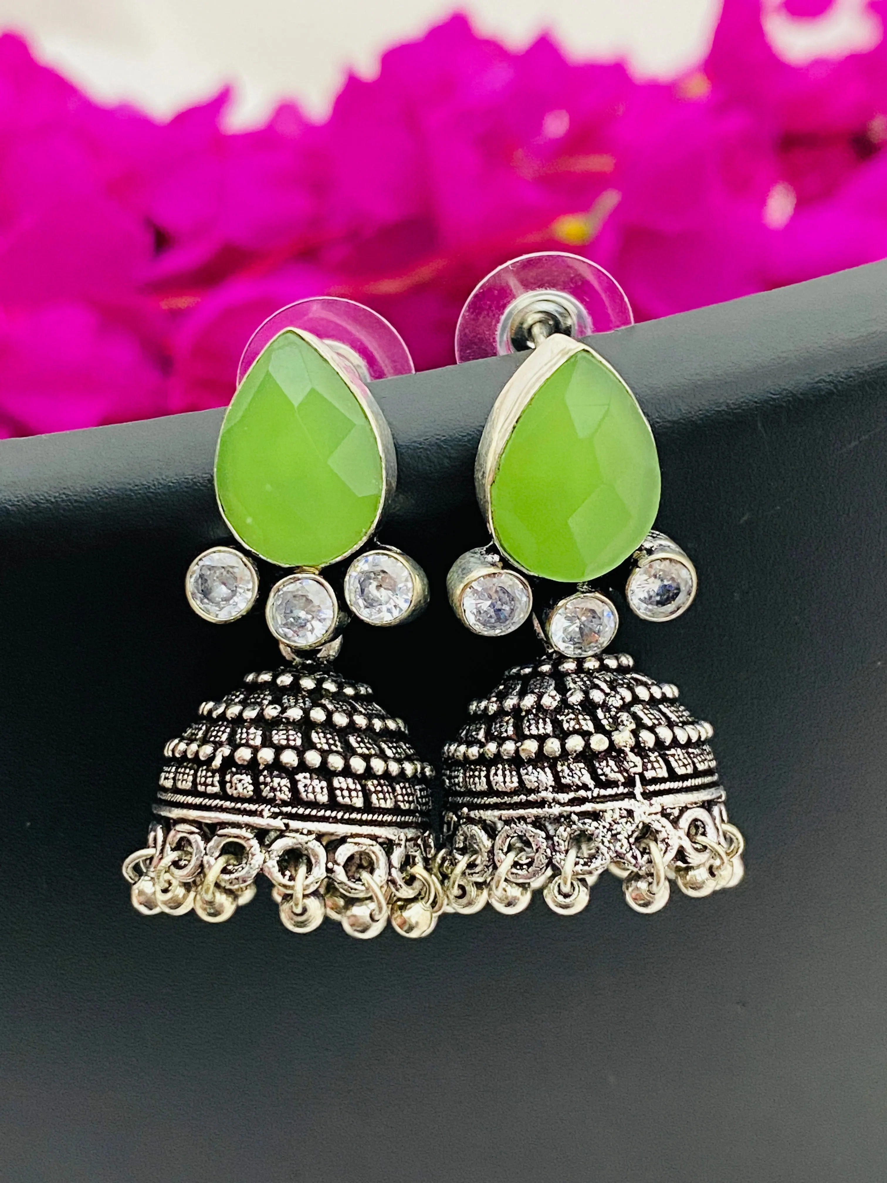 Lovely Green AD Stone Beaded Silver Toned Designer Jhumka Earrings With Black Pearl Drops